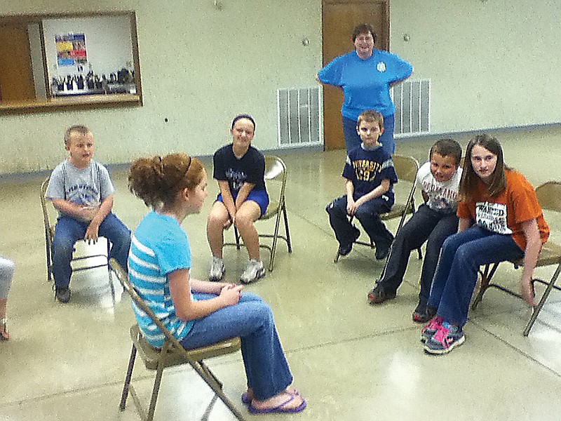 Ashlee Nichols (center) along with, from left to right, Trey Coffelt, Alyssa Reynolds, Kathy Gerlach (4-H Club Leader, Standing), Cody Nichols, Gage Reynolds and Courtney Matthews play the game Fruit Bowl which was directed by  game leader Keegan Borts (not shown).