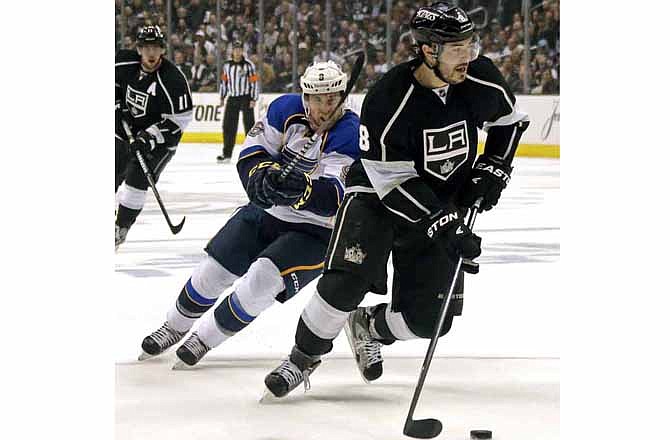 Kings defenseman Drew Doughty (8) moves the puck as he is chased by Blues left winger Jaden Schwartz during Monday's game in Los Angeles.