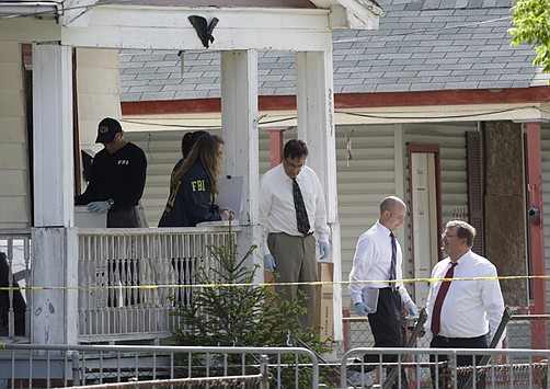 Law enforcement officials gather evidence at the crime scene Thursday where three women were held captive in Cleveland, Ohio. Ariel Castro, a 52-year-old former school bus driver, is being held on $8 million bail under a suicide watch in jail, where he is charged with rape and kidnapping.