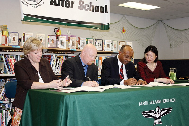 North Callaway Assistant Superintendent Sandy Haskins, left, signs a contract in 2012 with After School program director Brian Jobe, Confucius Institute director Handy Williamson Jr. and co-director Wen Ouyang, bringing Chinese cultural programs to the district. The program was one of a myriad Haskins was involved in implementing throughout her 25-year career with the district. Haskins is retiring this year.