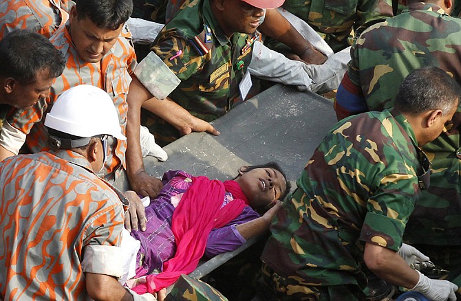 Rescuers carry a survivor pulled out from the rubble Friday of a garment factory building that collapsed in Saver, Bangladesh. Rescue workers in Bangladesh freed the woman buried for 17 days inside the wreckage where more than 1,000 people died.