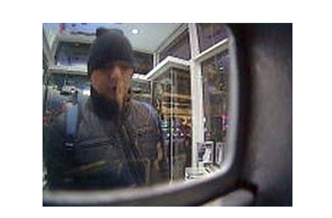 This Feb. 19, 2013 surveillance image released by the U.S. Attorney's Office in New York City shows a man referred to as "defendant Reyes" allegedly using fraudulent magnetic cards to steal money from one of several cash machines in Manhattan. 