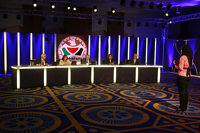 A Palestinian contestant, Soaar Salman, stands in front of the judges during the taping of the program "The President"  in the West Bank city of Bethlehem. "The President" is broadcast weekly on Maan TV, a popular independent Palestinian TV station. It offers contestants a chance to address the Palestinian people on what they would do on a variety of subjects if elected president. 
