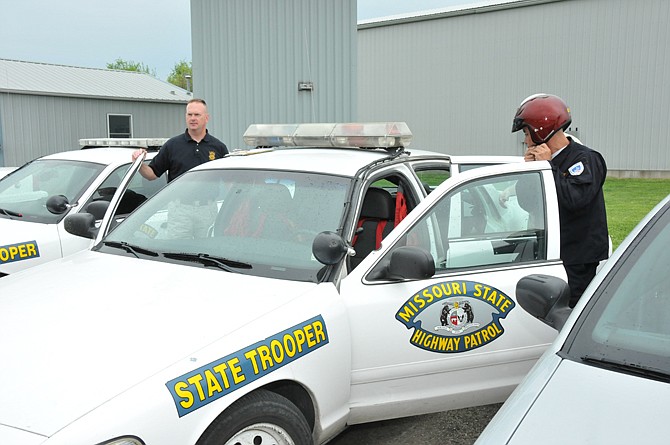 Francisco Vargas, a Costa Rican police officer, puts on his helmet to prepare for the Missouri Highway Patrol driving course as part of a Missouri National Guard State Partnership Program. Guiding Vargas through the course were Missouri State Trooper Bruce Baker and Air National Guard 1st Lt. Todd Cantwell, who served as the interpreter.