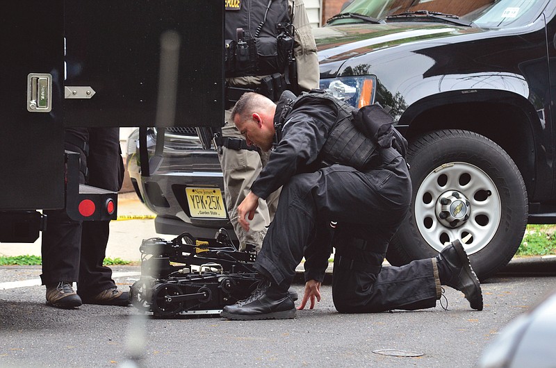A state police swat team member readies a robot to enter a home where a man had barricaded himself since Friday.