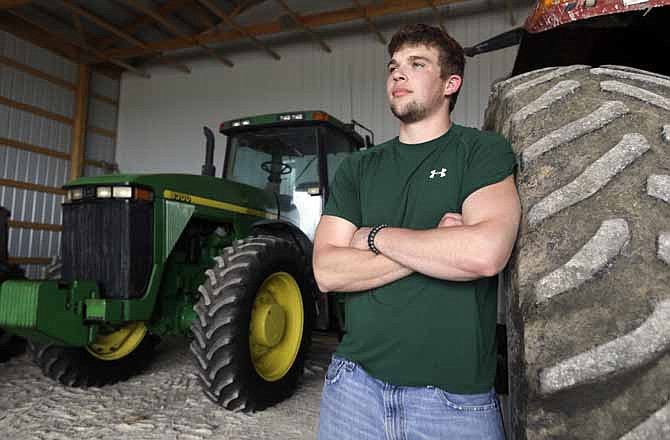 In this Wednesday, April 17, 2013 photo, Jake Anderson poses for a photo in an equipment shed on his family's farm in Williamsburg, Mo. Anderson didn't have to delve too deep into the University of Missouri's agricultural economics program before realizing he was destined to return to the 1,500-acre family farm. After all, that's been the Anderson family trade since 1891.