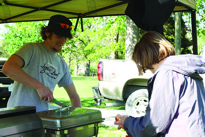 A vendor representing Legacy Beef serves a patron at the Taste of Local Missouri event on Saturday.