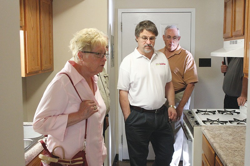 Fulton councilmembers Mary Rehklau, Mike West and Wayne Chailland examine new countertops Tuesday in a Fulton Housing Authority senior and disabled unit that had just been renovated.