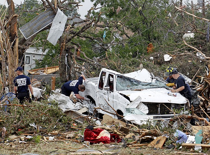 Crushed autos sit amid the rubble Thursday as emergency personnel continue search efforts to locate people that are unaccounted for in the destroyed Rancho Brazos neighborhood of Granbury, Texas. Ten tornadoes touched down in several small communities in North Texas overnight, leaving at least six people dead, dozens injured and hundreds homeless. 