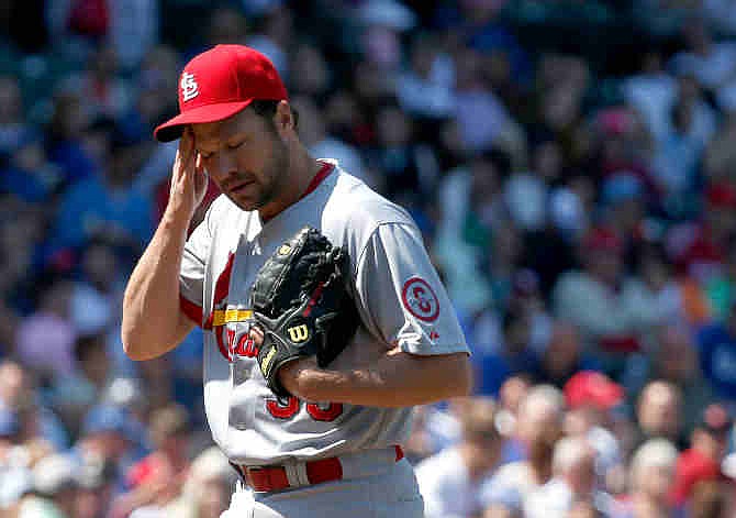 St. Louis Cardinals starting pitcher Jake Westbrook wipes his face during the fourth inning of a baseball game against the Chicago Cubs Wednesday, May 8 2013, in Chicago.