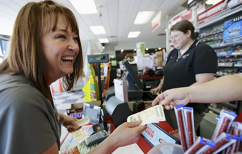 Cathy Munoz of Lincoln purchases Powerball tickets Friday for an office pool at a convenience store in Lincoln, Neb. The estimated Powerball jackpot has climbed to 600 million dollars.