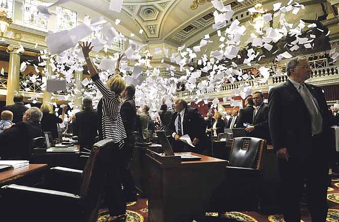 Members of the Missouri House of Representatives toss their papers into the air in celebration as House Speaker Rep. Timothy Jones (R-Eureka) strikes the gavel to adjourn the final day of the legislative session.