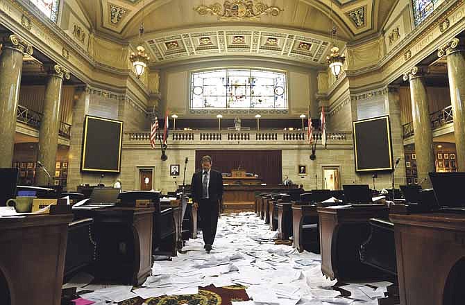 Missouri House of Representatives Director of Operations Brad Werner assesses the paper-strewn floor as he exits the House Chamber following the adjournment of the final day of the legislative session.