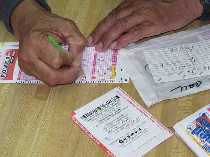 Armous Peterson fills out his slip for the Powerball lottery at Jimmy's Mart on Saturday, May 18, 2013, in Columbia, S.C. Peterson keeps track of what numbers he plays from week to week.