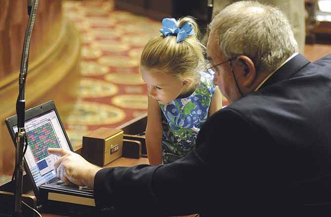 Margaux Harris sits alongside her grandfather, state Rep. Mike Lair of Chillicothe, as the two watch from his desk Friday, observing the vote on a House bill displayed in real time in the closing minutes of the last day of the Missouri Legislature's 2013 session.