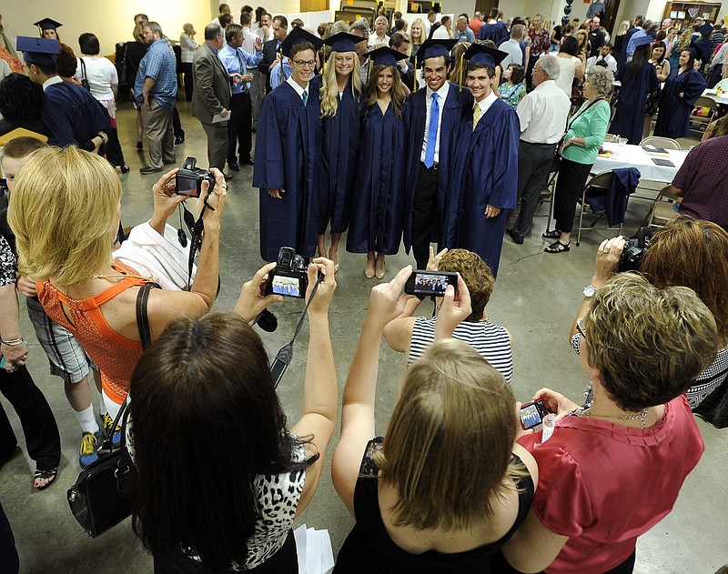 Helias graduates pose for multiple group photos in the undercroft at St. Joseph Cathedral following Sunday's graduation liturgy and commencement ceremony.