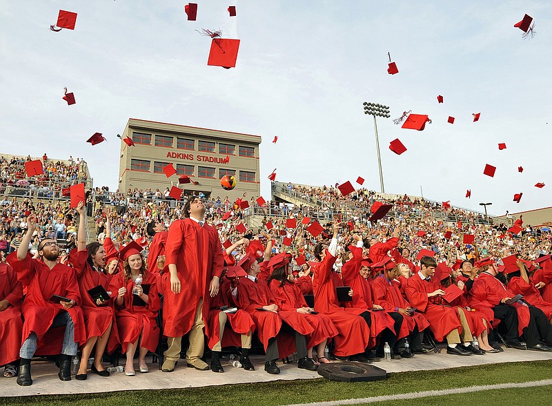Members of the Jefferson City High School Class of 2013 toss their caps into the afternoon sky at the conclusion of Sunday's commencement exercise at Atkins Stadium.