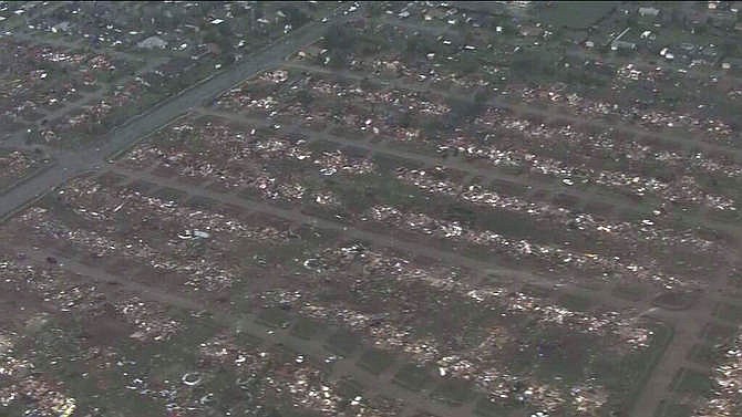 This photo provided by KFOR-TV shows homes flattened outside Moore, Okla., Monday, May 20, 2013. A monstrous tornado roared through the Oklahoma City suburbs Monday, flattening entire neighborhoods, setting buildings on fire and landing a direct blow on an elementary school. 