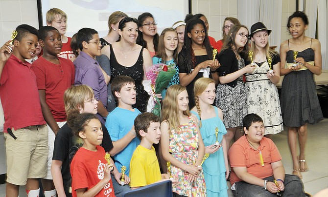 Cast and crew of the movie "Last Thing I Remember" hold up their "Oscars" as they pose for a group photograph after the premiere of Tuesday's movie at Thomas Jefferson Middle School. After students read the book "Last Thing I Remember," they asked why there wasn't a movie about the book. After several weeks of working the film, it premiered Tuesday with an audience made up of students and parents.