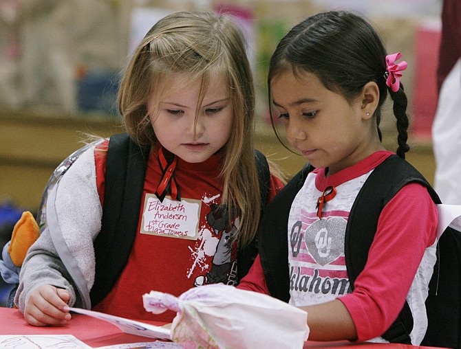 Classmates and survivors from Plaza Towers Elementary School Elizabeth Anderson, 6, left, and Rylee Pino, 6, read messages from other children in the area during a visit to Eastlake Elementary School in Moore, Okla.