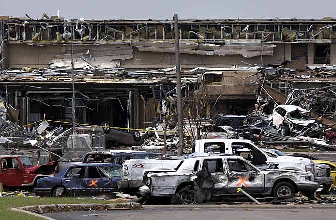 Destroyed vehicles and other tornado debris pile-up in front of the Moore Medical Center along I-35 in Moore, Okla., Thursday May 23, 2013.