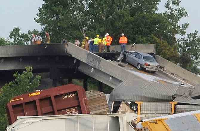 Emergency personnel respond to the scene of a train derailment near Rockview, Mo. on Saturday, May 25, 2013. The National Transportation Safety Board has launched an investigation into the cause of a cargo train collision that partially collapsed a highway overpass in southeast Missouri, injuring seven people. (AP Photo/The Southeast Missourian, Fred Lynch)