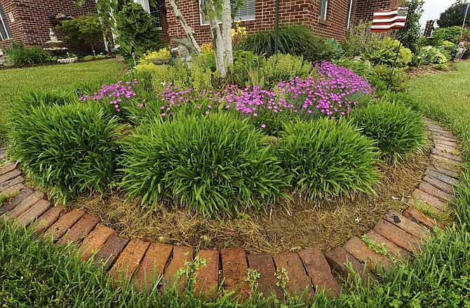 The bricks surrounding portions of Dick and Barb Crader's gardens are reclaimed antique street bricks made by Missouri Block in Moberly that once paved the way for travelers along High Street.