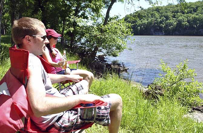 Joel Isenburg and Valerie Berry, of Des Moines, Ia., lounge by the water before setting up their tent during Memorial Day Weekend in 2013 at central Missouri's Lake of the Ozarks State Park.