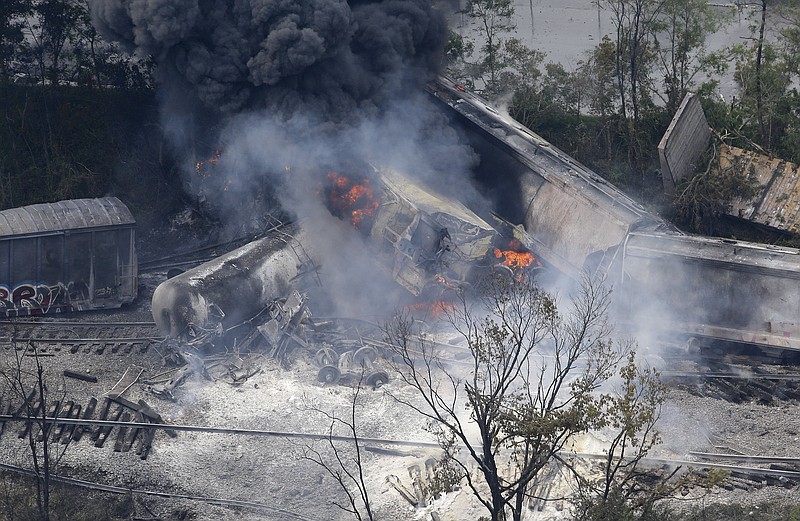 A fire burns Tuesday at the site of a CSX freight train derailment in Rosedale, Md., where fire officials say the train crashed into a trash truck, causing an explosion that rattled homes at least a half-mile away and collapsed nearby buildings.