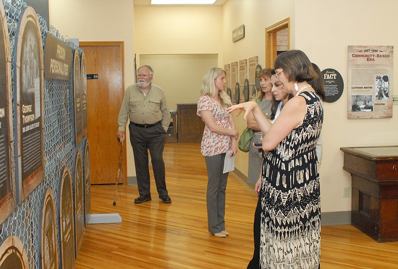 Exhibit designer Cindee Herrick and Tisha Spencer, graphics designer with Firehouse Design, talk with guests Tuesday at the open house of the Missouri State Penitentiary Museum on the second floor of the Convention and Visitors Bureau on High Street in Jefferson City.