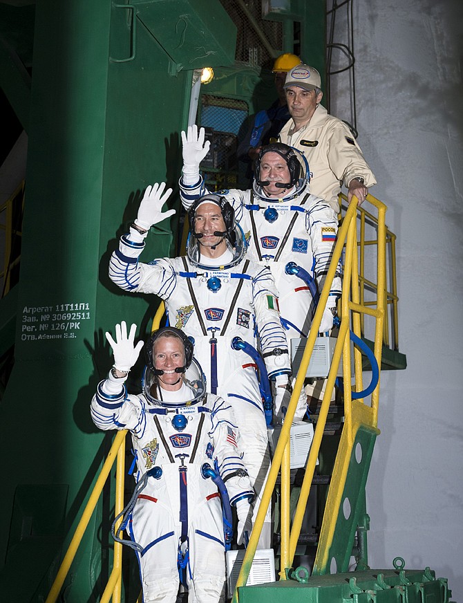 NASA Expedition 36/37 Soyuz Commander Fyodor Yurchikhin of the Russian Federal Space Agency, top, Flight Engineers Luca Parmitano of the European Space Agency, center, and Karen Nyberg of NASA, wave as they board the Soyuz rocket ahead of their launch to the International Space Station, early Wednesday, in Baikonur, Kazakhstan.