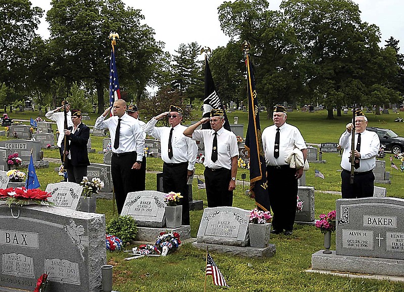 VFW members conducting the Memorial Day ceremony Monday, May 27, at Annunciation Catholic Cemetery render a salute as "Taps" is played. 