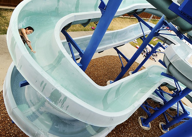 A youngster beats the heat by blasting down the water slide at Jefferson City's Memorial Park Aquatic Center in 2012.
