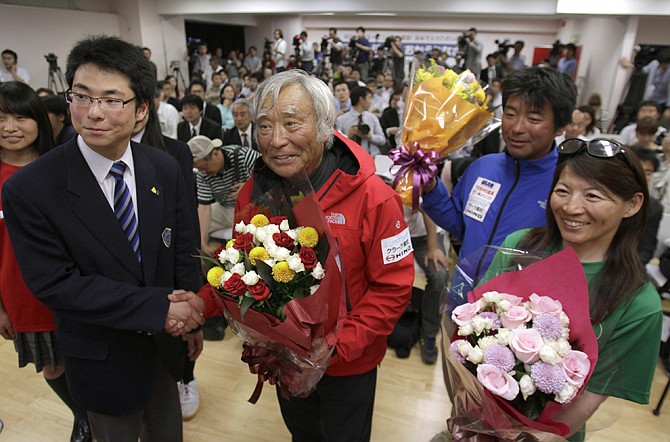 Yuichiro Miura, center, an 80-year-old Japanese mountaineer who became the oldest person to reach the top of Mount Everest last Thursday, poses for photographers before speaking at a press conference. Miura said he almost died on his decent and will not climb the mountain again. 