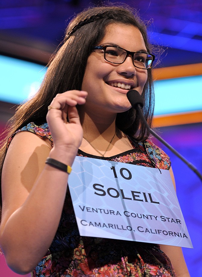 Soleil Roselinda Jones, 13 of Oxnard, Calif. waves to the word announcer Wednesday as she spells her word during the second round of the Scripps National Spelling Bee.
