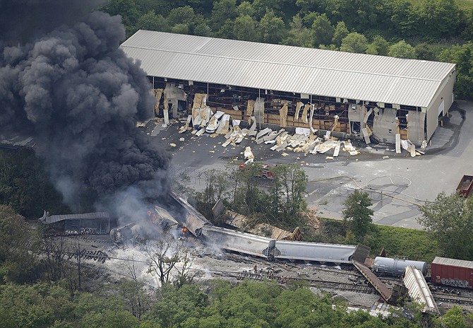 A fire burns at the site of a CSX freight train derailment, Tuesday, in White Marsh, Md., where fire officials say the train crashed into a trash truck, causing an explosion that rattled homes at least a half-mile away and collapsed some nearby buildings, setting them on fire.