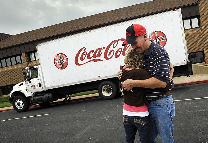 Lisa Sandbothe hugs her boyfriend, Jefferson City Coca-Cola employee John Otto, while wishing him safe travels as he prepares to climb into the driver's seat Friday and embark from Concord Baptist Church on a relief mission to deliver supplies to tornado victims in Moore, Okla. Jefferson City Coca-Cola donated the truck, fuel and several pallets of water to accompany Otto, Concord executive pastor Peter Livingston, and his son Josh Livingston on their relief mission to Oklahoma.