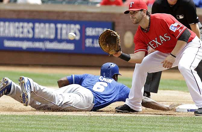 Kansas City Royals Lorenzo Cain (6) beats the pick off throw to first against Texas Rangers first baseman Mitch Moreland (18) during the second inning of a baseball game Saturday, June 1, 2013, in Arlington, Texas.