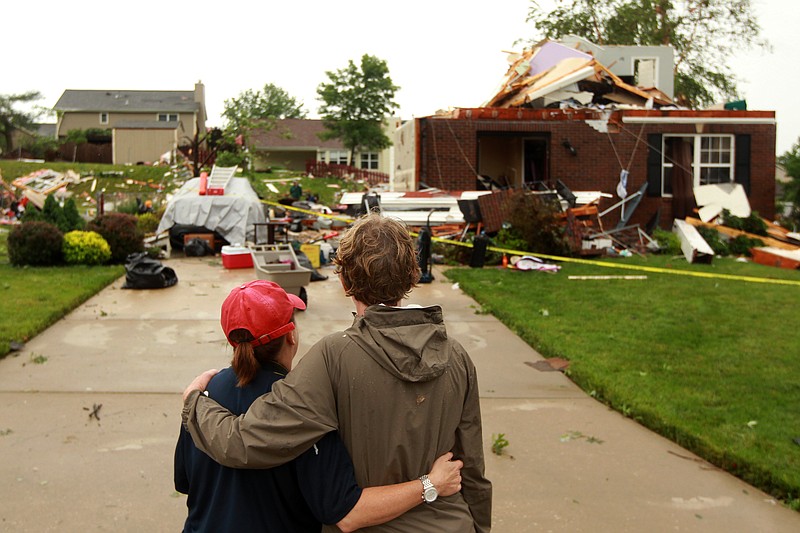 Ashley Slinkard, left, embraces Becky Brady as they look over the destroyed home of Brady's daughter on Saturday, June 1, 2013 after a overnight storm in St. Charles, Mo.  Emergency officials set out Saturday morning to see how much damage a violent burst of thunderstorms and tornadoes caused as it swept across the Midwest overnight.