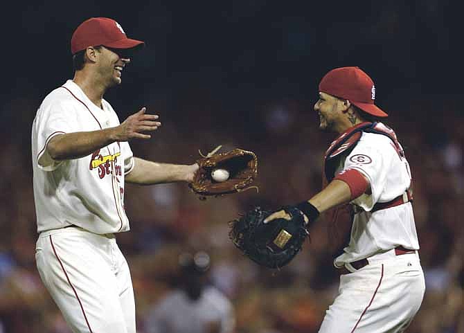St. Louis Cardinals starting pitcher Adam Wainwright, left, is congratulated by catcher Yadier Molina after throwing a complete baseball game against the San Francisco Giants in the second game of a doubleheader on Saturday, June 1, 2013, in St. Louis. The Cardinals won 7-1. (AP Photo/Jeff Roberson)