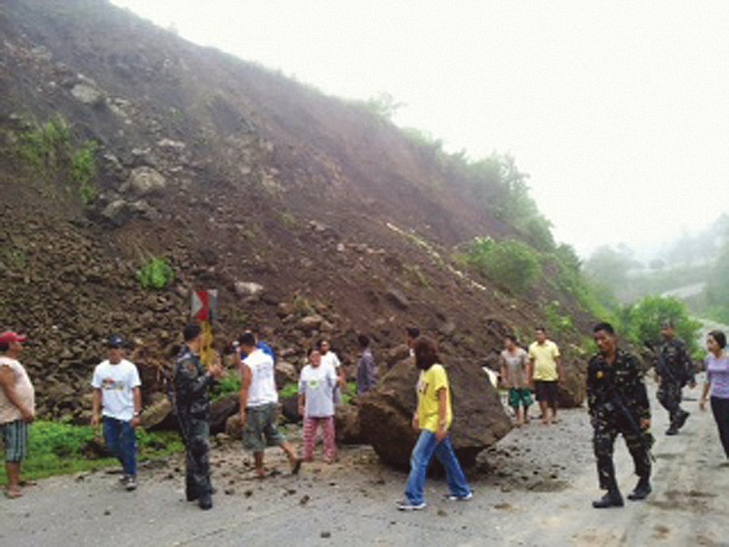 Residents look at boulders that partially blocked a highway after an earthquake in North Cotabato in southern Philippines.