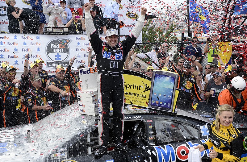 Tony Stewart celebrates in Victory Lane after he won the FedEx 400 on Sunday at Dover International Speedway in Dover, Del.