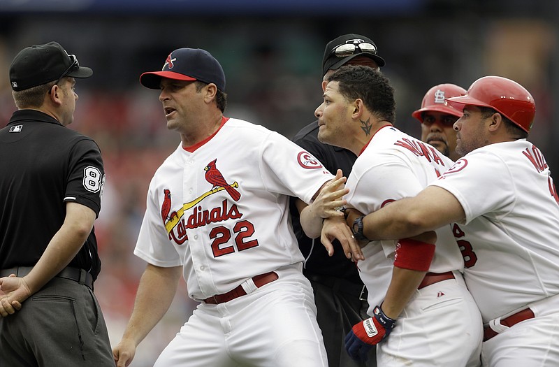 Cardinals catcher Yadier Molina (second from right) is held back by his brother, first base coach Bengie Molina (right), while yelling alongside manager Mike Matheny (22) at umpire Clint Fagan (left) after Yadier Molina and Matheny were thrown out of Sunday's game by Fagan during the third inning against the Giants in St. Louis.