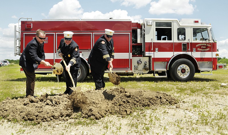 Mayor Eric Struemph, left, Interim Fire Chief Jason Turner and Assistant Fire Chief Bill Barbour dig into the mound and toss dirt during the groundbreaking ceremony Friday for the new Fire Station 3 to be built off Missouri 179, just north of Industrial Drive. 