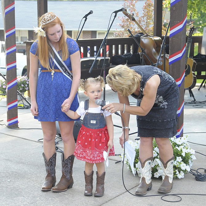 Karsyn Duncan answered questions from organizer Susie Oliver as part of the Little Miss and Mr. Russellville contest Friday evening. Duncan is holding the hand of 2012 Miss Teen Russellville Madison Oliver.