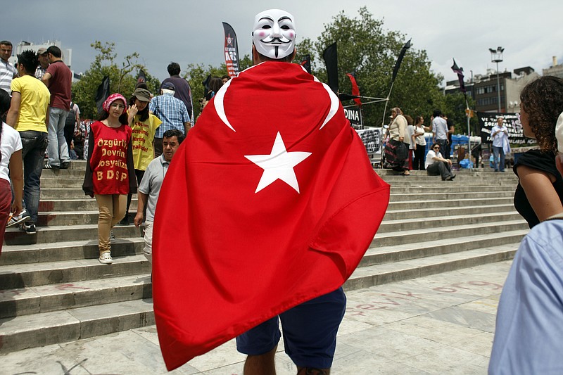 Giulio Giacomazzi, 34, a tourist from Brazil wearing a Turkish flag and a mask enters Gezi Park on Friday, near Taksim square in Istanbul. Giacomazzi, who was in Istanbul airport for a transit flight from Taiwan, said he decided to cancel his flight back to Brazil and stay in Istanbul in order to take part in the protests.