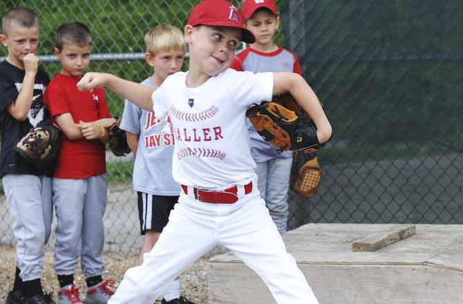 With his fellow campers looking on, 7-year-old Myles Gresham works on his pitching form during the Jefferson City Jays' youth camp held last week at Vivion Field.