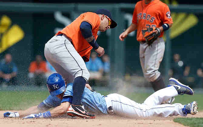 Kansas City Royals' Chris Getz, bottom, beats the tag by Houston Astros shortstop Ronny Cedeno during the eighth inning of a baseball game at Kauffman Stadium in Kansas City, Mo., Sunday, June 9, 2013. The Royals defeated the Astros 2-0.