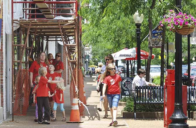 Students and leaders from First Presbyterian Vacation Bible School aren't fazed by the scaffolding as they walk through the downtown area Friday. Downtown Jefferson City is undergoing revitalization, some of which includes changing storefronts, such as here at Coffee Zone. 