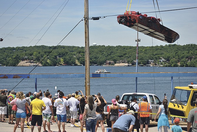 Guests watch in awe and take photos as some of the larger, faster PX class boats are lowered into the Lake of the Ozarks by a crane before taking to the OSS-sanctioned event's on-water course Saturday.